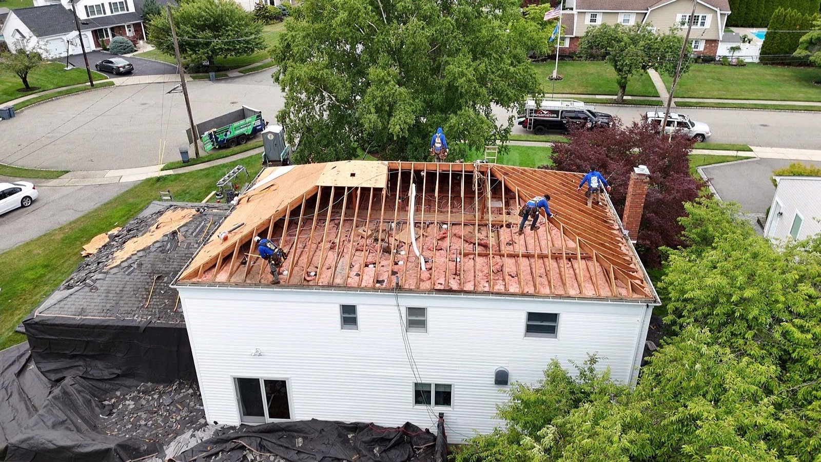 LGM crew resheathing a ranch roof with exposed rafters and insulation