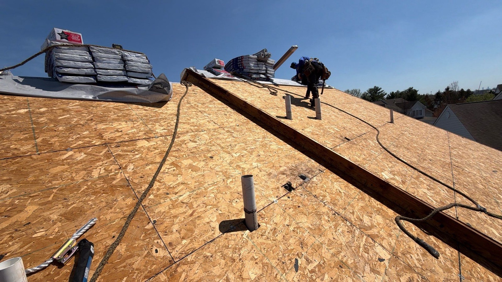 Full LGM crew working a large suburban roof replacement from above
