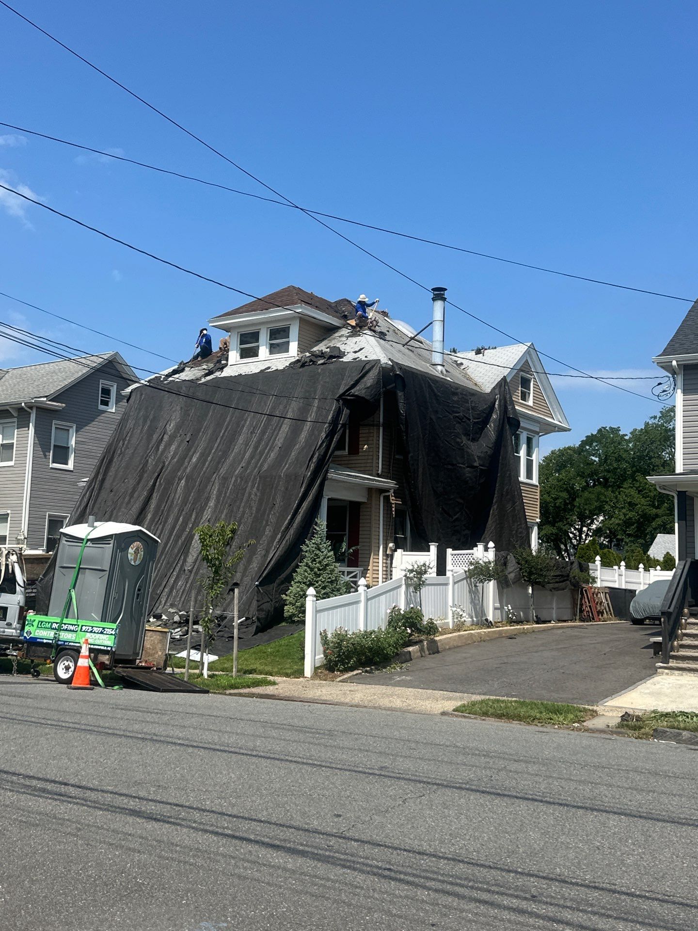 Street view of a Victorian tear-off with protective tarps draped